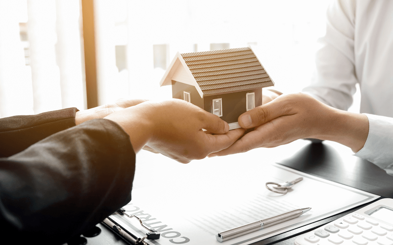住宅模型と書類を扱う手元